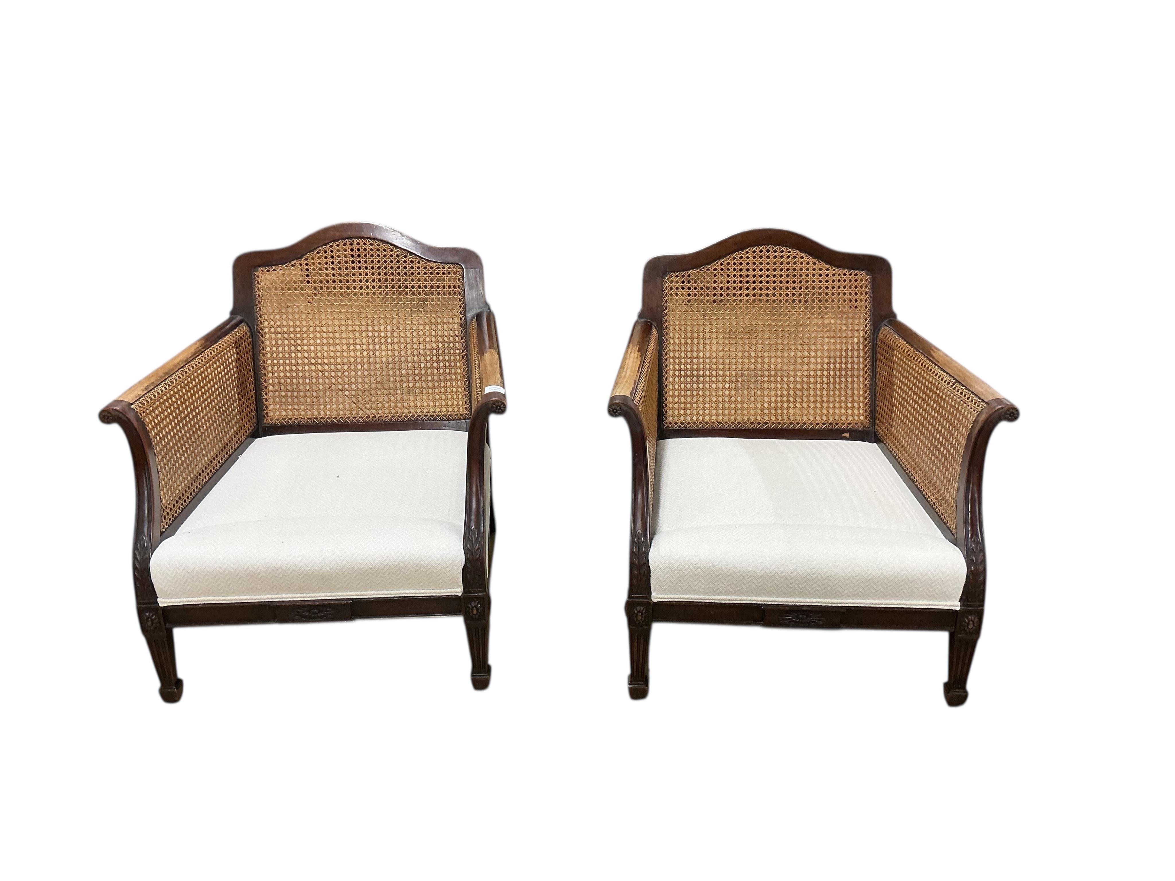 A pair of early 20th century mahogany bergere armchairs, width 75cm, depth 78cm, height 80cm